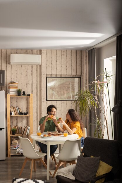 Couple déjeunant avec des sandwichs à la maison