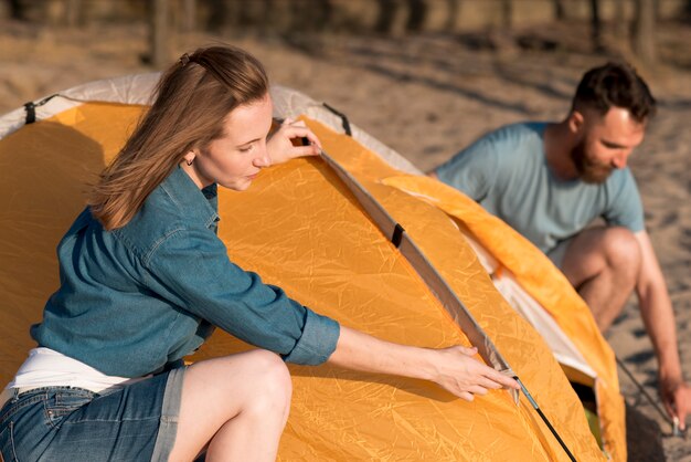 Couple démontant une tente de camping