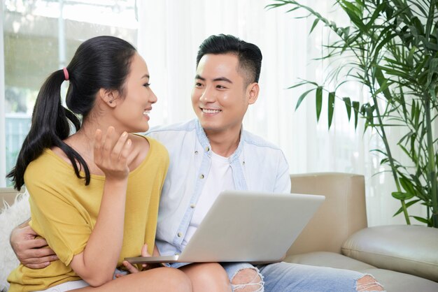 Couple de détente à l'aide d'un ordinateur portable sur un canapé