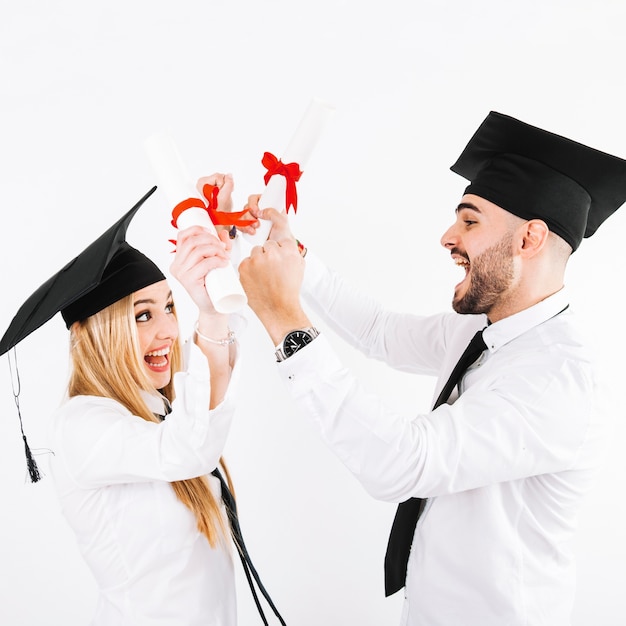 Photo gratuite couple avec des diplômes s'amusant