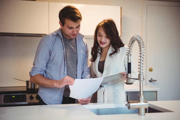 Couple discutant sur tablette numérique dans la cuisine