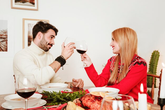 Couple avec du vin au dîner de Noël