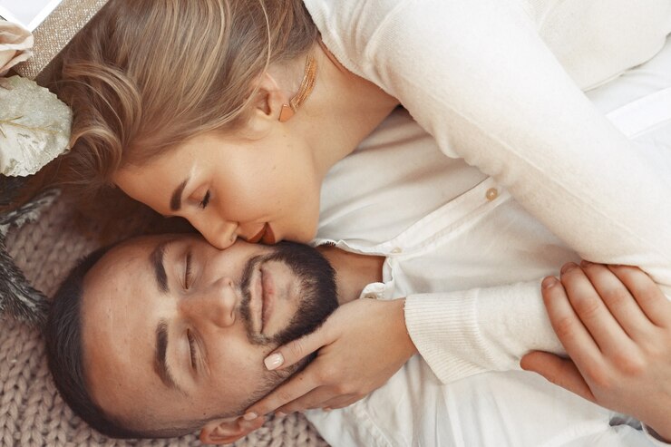 Photo gratuit couple élégant allongé sur un lit à la maison