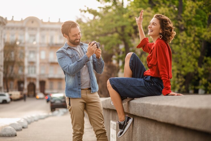 Photo gratuit couple élégant amoureux assis dans la rue lors d'un voyage romantique, prenant une photo