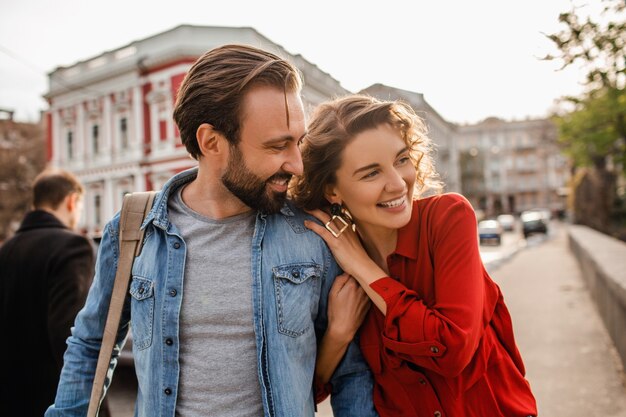 Couple élégant amoureux marchant embrassant dans la rue en voyage romantique