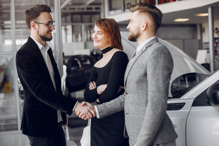 Photo gratuit couple élégant et élégant dans un salon de l&#39;automobile