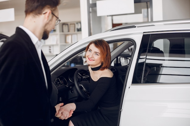 Couple élégant et élégant dans un salon de l&#39;automobile