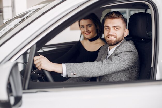 Couple élégant et élégant dans un salon de l&#39;automobile