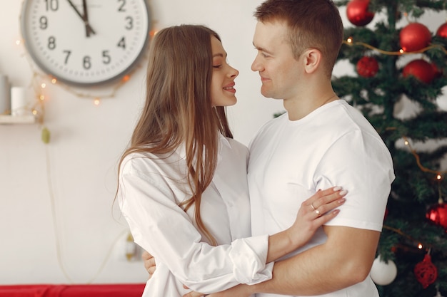 Couple élégant à la maison près de l'arbre de Noël