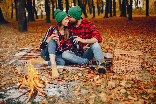 Couple élégant passe du temps dans un parc en automne