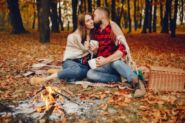 Couple élégant passe du temps dans un parc en automne