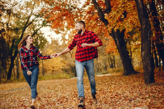 Couple élégant passe du temps dans un parc en automne