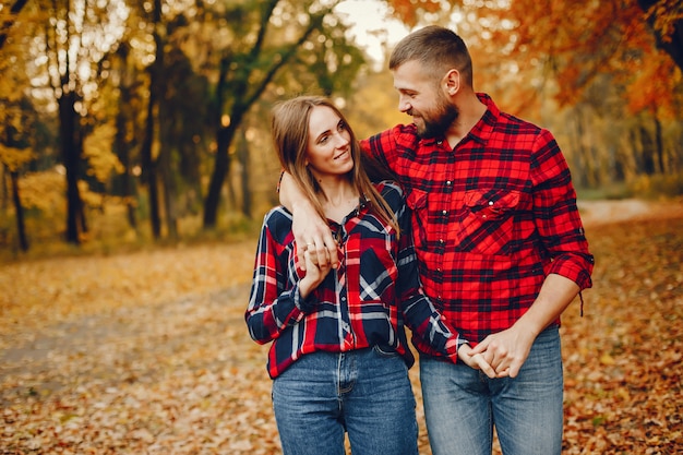 Couple élégant passe du temps dans un parc en automne