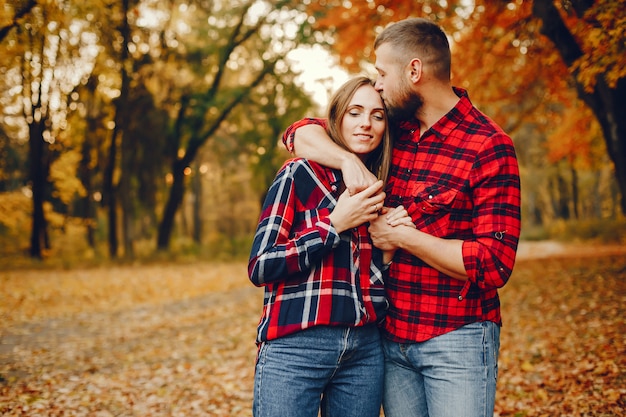 Couple élégant passe du temps dans un parc en automne