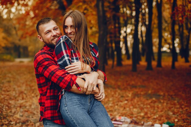 Couple élégant passe du temps dans un parc en automne