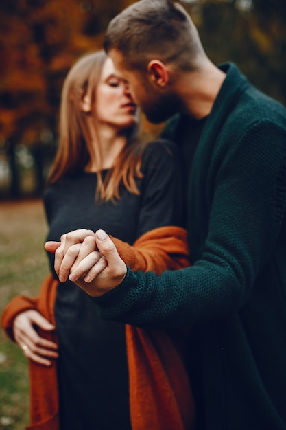 Couple élégant passe du temps dans un parc en automne