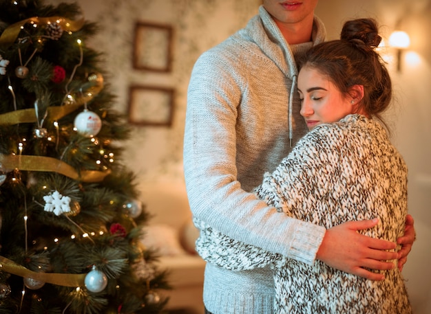 Couple embrassant à l&#39;arbre de Noël