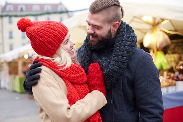 Couple embrassant sur le marché de Noël