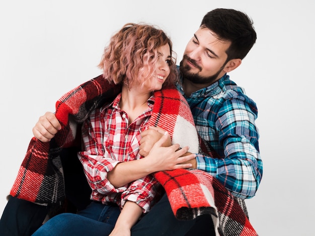 Couple embrassé avec une couverture pour la Saint-Valentin