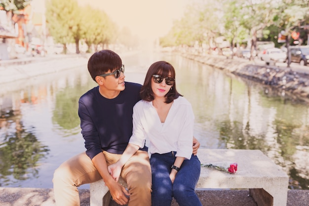 Photo gratuite couple enlacé sur un banc dans un parc