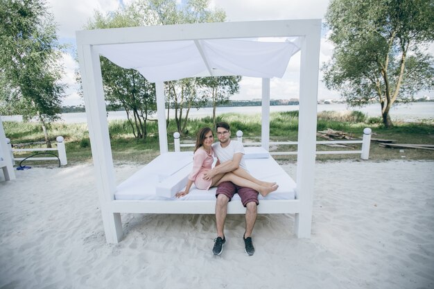 Couple enlacé sur un lit double à la plage