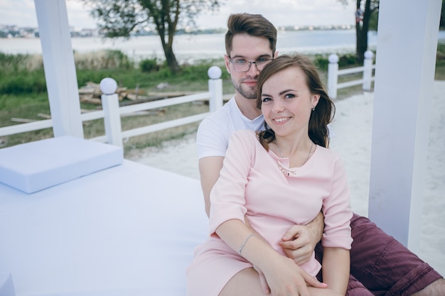 Couple enlacé sur un lit double à la plage