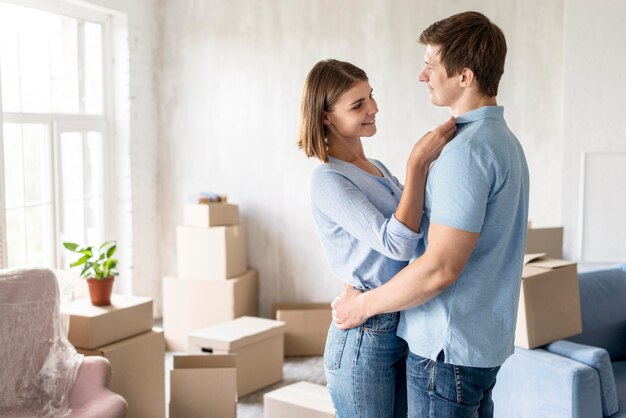 Couple enlacé à la maison tout en faisant ses valises pour déménager