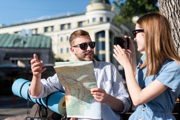 Photo gratuite couple à l'extérieur avec sac à dos et carte