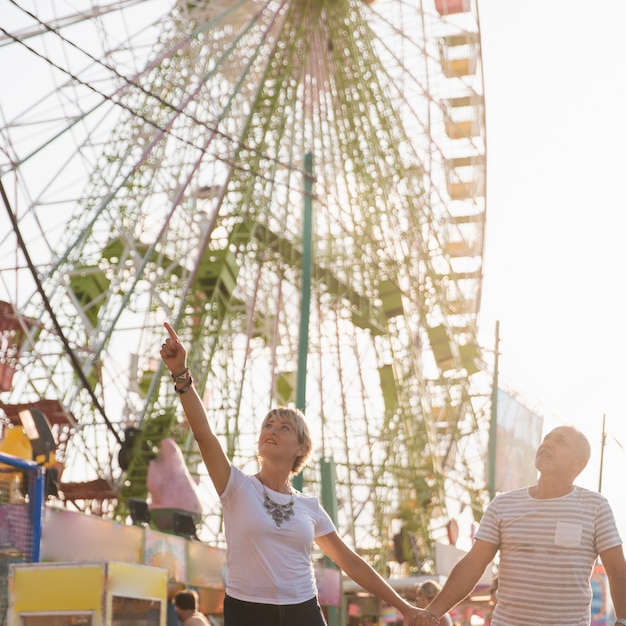 Photo gratuite couple à faible angle avec grande roue