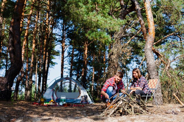 Couple à faible angle avec tente de camping pendant la nuit