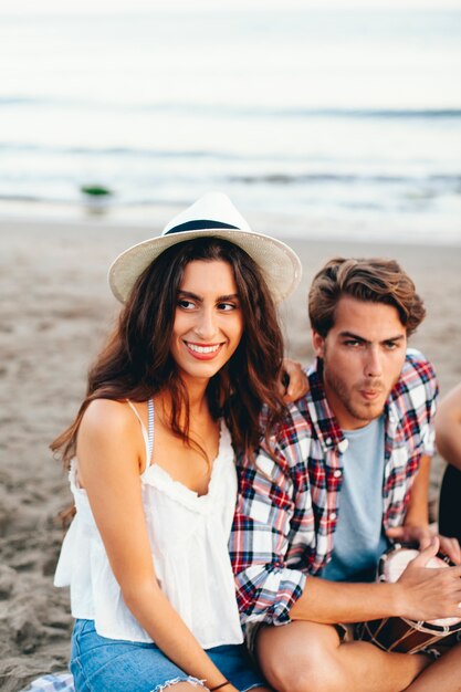 Couple de fête assis à la plage