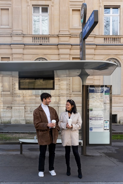 Couple français attendant à la gare pour prendre le bus et boire du café
