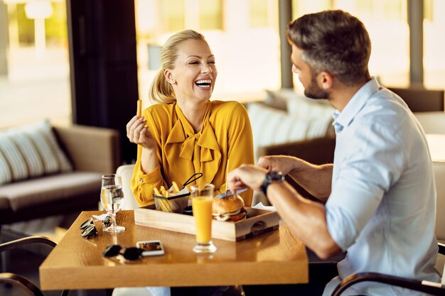 Couple gai parlant tout en déjeunant dans un restaurant