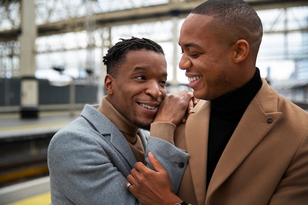 Photo gratuite couple gay à la gare lors d'un rendez-vous