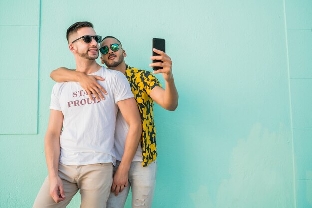 Couple gay prenant un selfie avec téléphone portable.