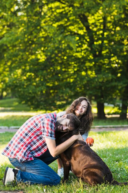 Couple heureux aimer leur chien dans le jardin