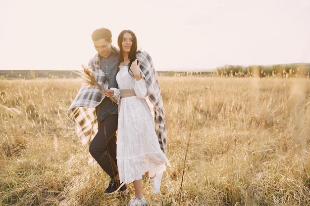 Couple heureux en amour dans le champ de blé au coucher du soleil