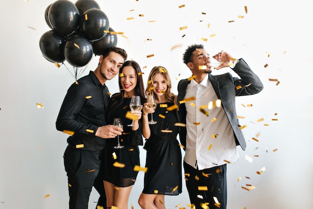 Couple heureux avec des ballons célébrant l'anniversaire avec leurs amis