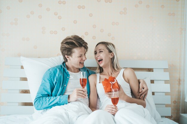 Couple heureux, boire du vin dans la chambre