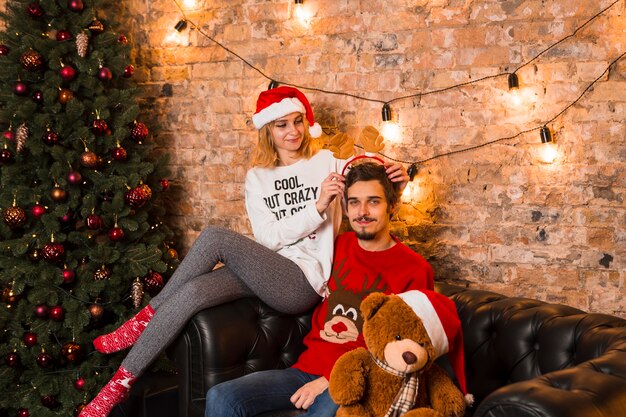 Couple heureux célébrant Noël avec ours en peluche