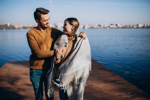 Couple heureux avec couverture au bord de la rivière