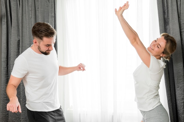 Photo gratuite couple heureux à l'intérieur dans la chambre