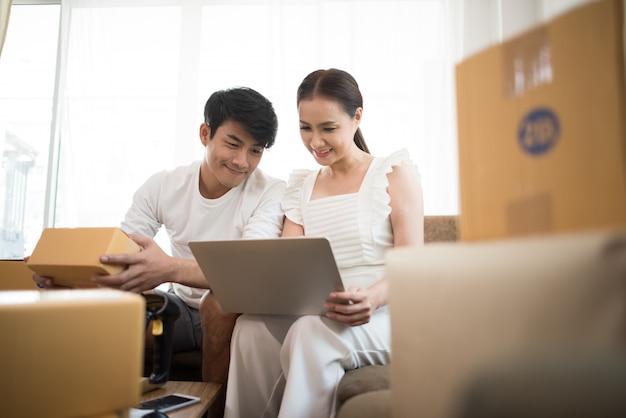Couple heureux à la maison avec les affaires en ligne, marketing en ligne et travail indépendant