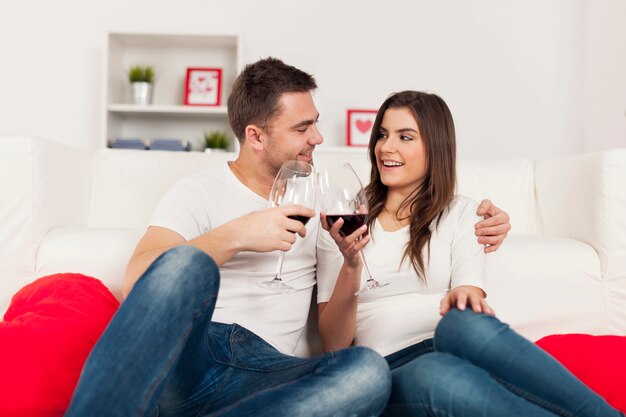 Couple heureux, passer du temps romantique avec du vin rouge à la maison