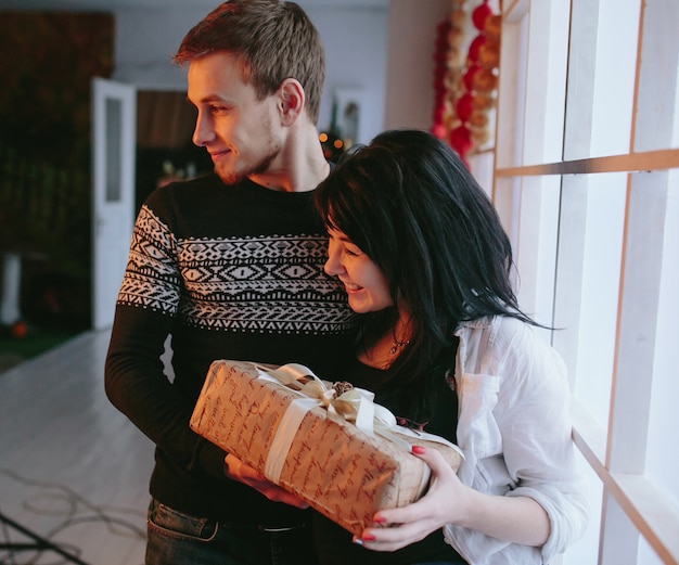 Couple heureux posant avec le cadeau de noël