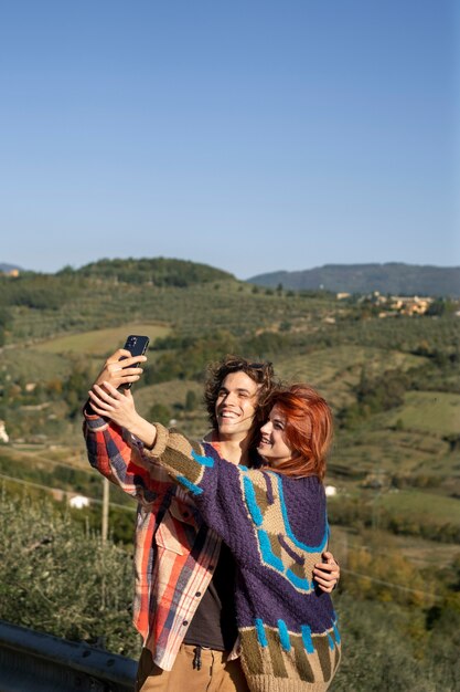 Couple heureux prenant selfie shot moyen