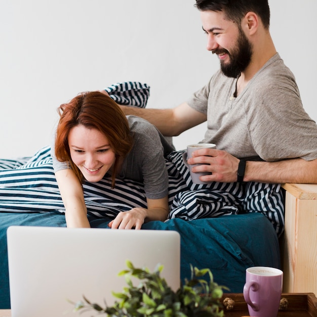 Couple heureux en regardant un ordinateur portable