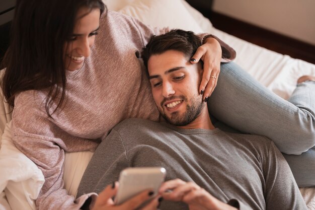 Couple heureux en regardant téléphone