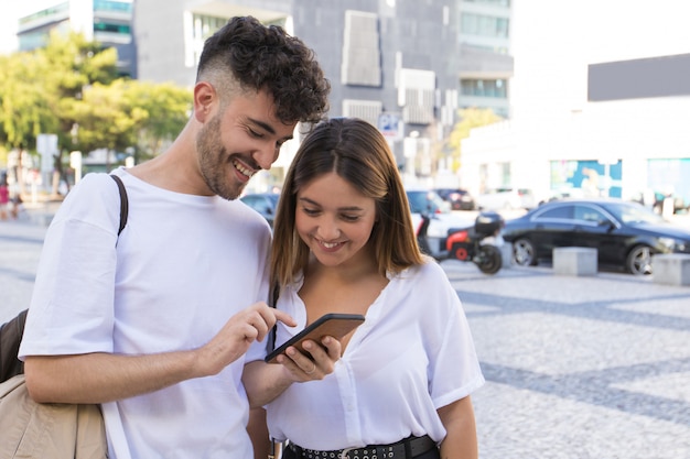 Couple heureux en regardant la vidéo sur cellule