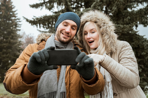 Photo gratuite couple en hiver prenant une vue de face de selfie